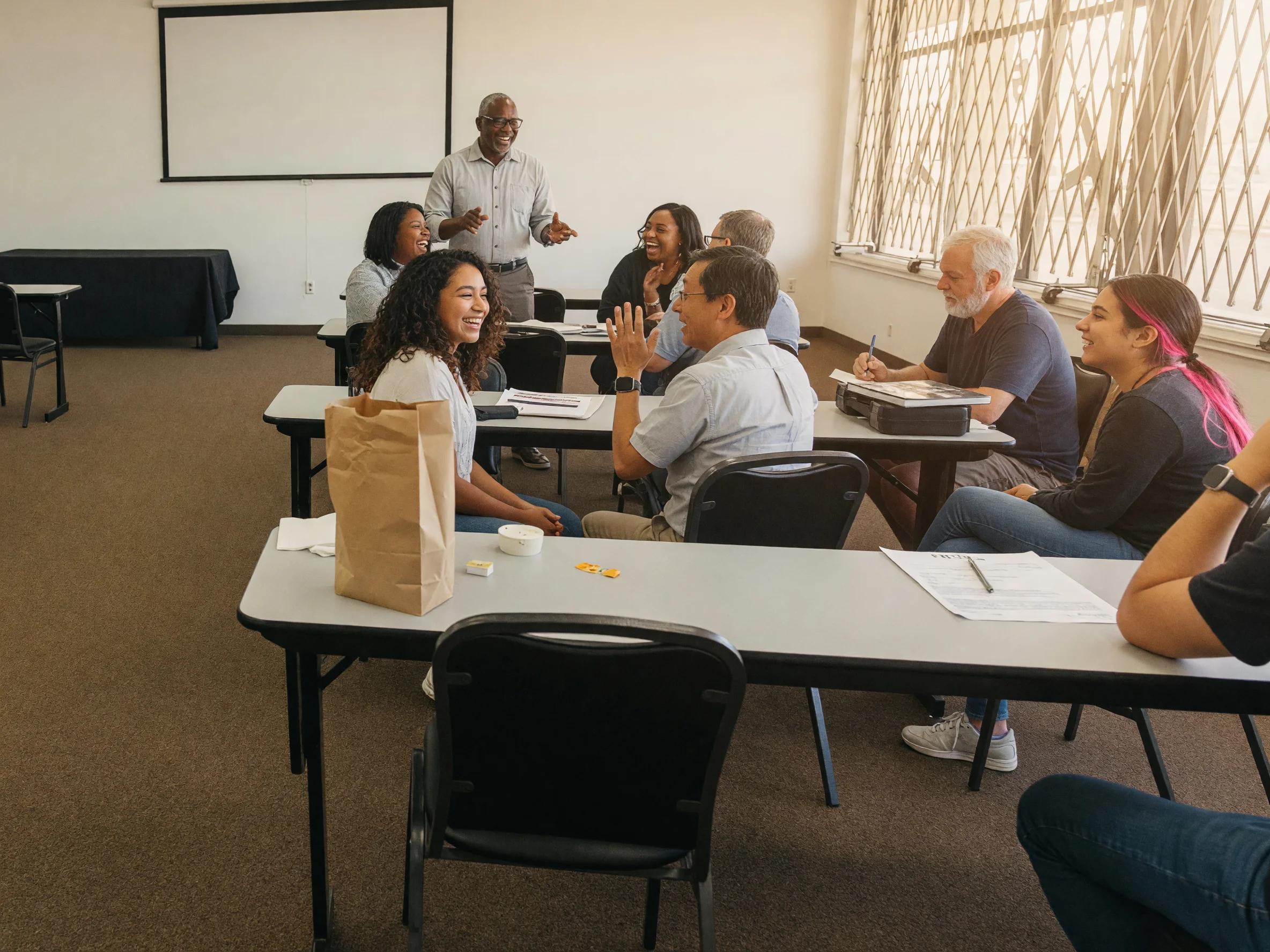 Students laughing with their instructor during a relaxed firearms safety class