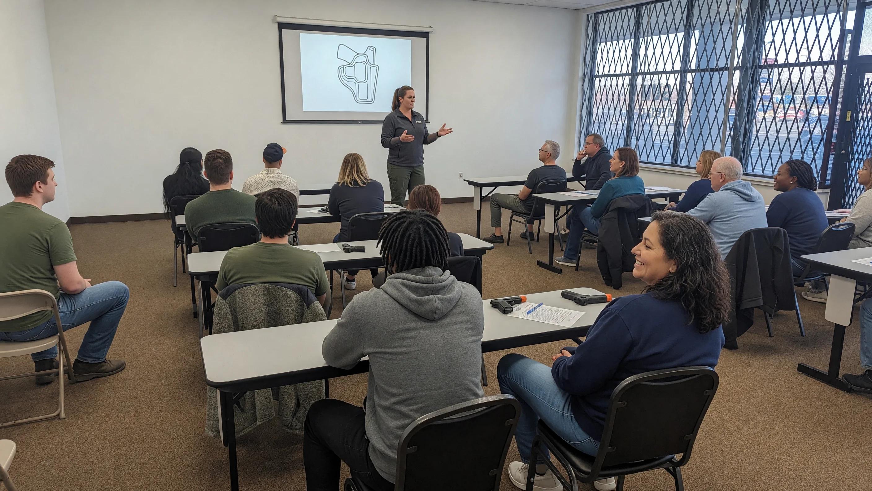 Woman instructor teaching a concealed carry class with a holster diagram on the screen